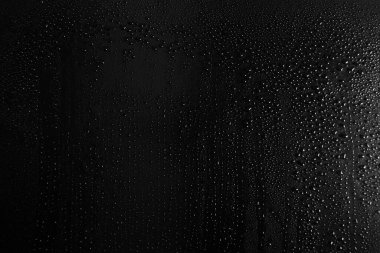 Koyu cam arkaplanda su damlaları