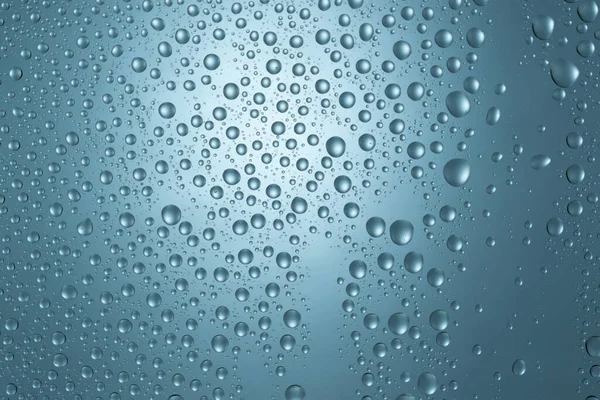 蓝色玻璃质感背景上的水滴 — 图库照片