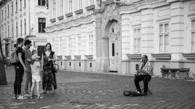 Sokakta saksafon çalan bir adamın siyah beyaz fotoğrafı. Timisoara, Romanya-Haziran 5, 2020