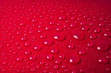 Kırmızı cam arkaplanda su damlaları
