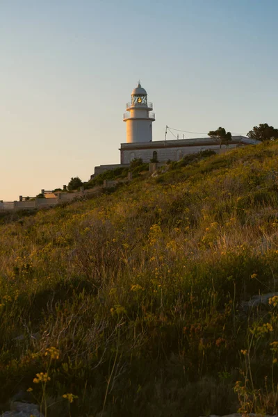 sunrise on the coast with a lighthouse in the background