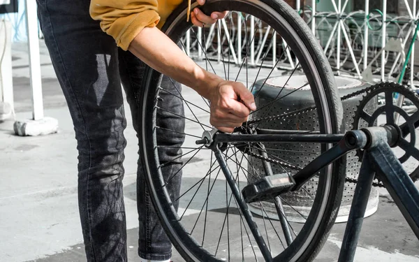 自転車の車輪を固定するスパナを持つ機械的な男 — ストック写真