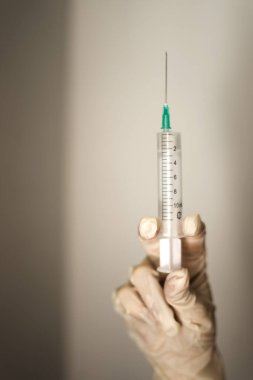 İğne yapmaya hazır bir doktorun elinde tıbbi şırınga.