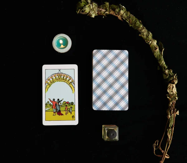 Bir şişe özü, mumu ve adaçayı dallı tarot kartları.