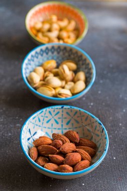 Masada fındıklar, bademler, kaju fıstıkları ve mavi fındıklar. Renkli fındık takımı.