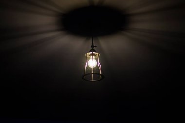 Tavanda ampul ve lamba, karanlık ve aydınlık, arka planda gölgeler ve ışıklar. Geometrik gölgeler.