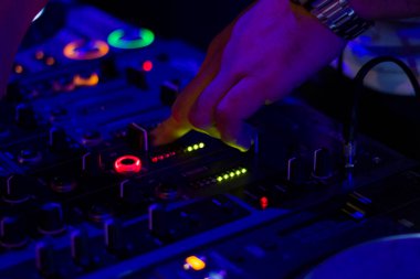 TBILISI, GEORGIA - MART 02, 2018: Gece kulübü müzik enstrümanı DJ kumandanı ve DJ elleri, müzik sahnesi. Color Light Music Instrument Arkaplanı. Müzik karıştırıcı.