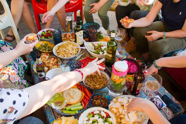 Masa manzarası, insanlar el ele tutuşup yemek yiyor. Arkadaşlar Tiflis, Georgia 'da yemek yiyip içiyorlar..