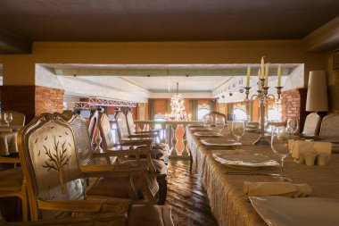 Restorasyon masası servis tabakları, kaşıklar ve bıçaklar, bardaklar ve sandalyeler, iç mekan ve hiç kimse. Tiflis, Gürcistan.