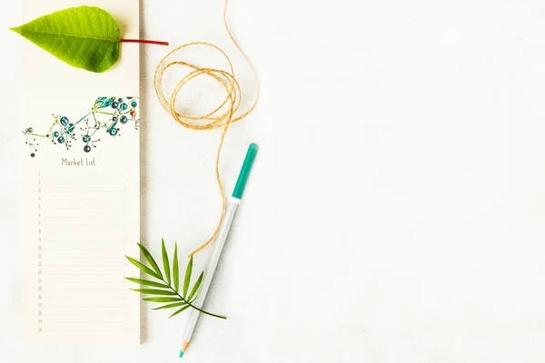 Notebook, pencils and plants on the white background, studio shot. Colorful stationery things and accessories. Marketing photos for business and web.