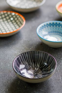 Siyah arkaplan ve geometri dokusunda renkli boş kaseler.