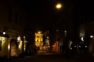 VILNIUS, LITHUANIA - 17 EKİM 2017: gece sokağı, turist ve sokak lambaları. Vilnius caddesinde gece durumu. Binalar ve simgeler.