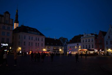 TALLINN, ESTONIA - 20 Ekim 2017: Şehir manzarası binalar, çatılar, mimari, tarih işaretleri ve geceleri sokaktaki insanlar.