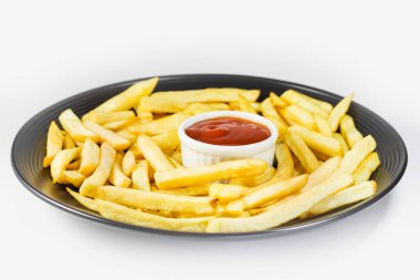 Siyah tabakta patates kızartması ve ketçap, beyaz arka plan.. 