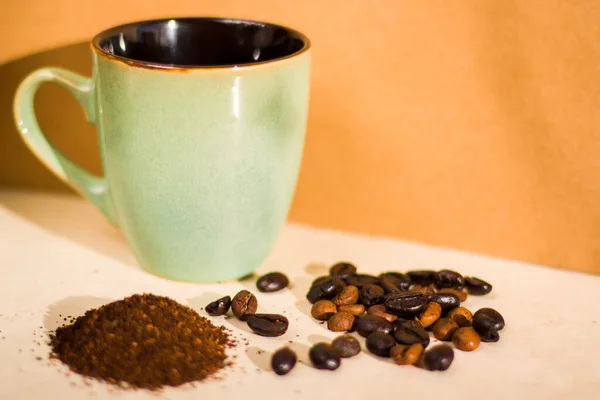 Roasted coffee beans and grained coffee seeds, studio shot, book and cup