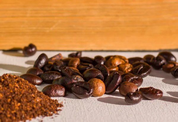 Roasted coffee beans and grained coffee seeds, studio shot, book and cup