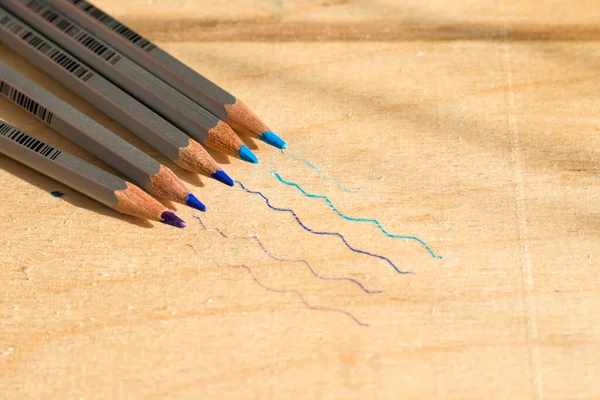 Pencil colors painting instruments on the table, pencil sets. Blue colors.