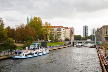 Berlin nehrinde tekneler, tekneli turistik geziler, Almanya 'daki şehir merkezinde beyaz büyük tekneler.