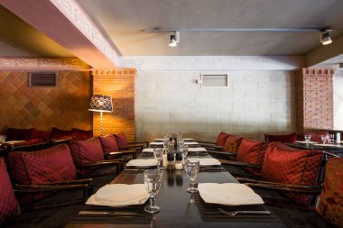 Restorasyon masası servis tabakları, kaşıklar ve bıçaklar, bardaklar ve sandalyeler, iç mekan ve hiç kimse. Tiflis, Gürcistan.