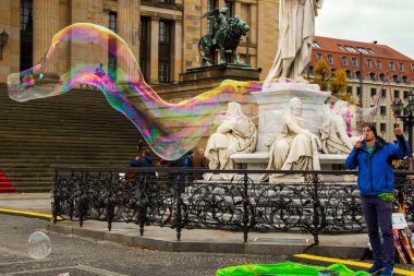 Berlin caddesinde sabun köpükleri, Almanya. Adam konser salonunun yakınında insanları ve turistleri eğlendiriyor..