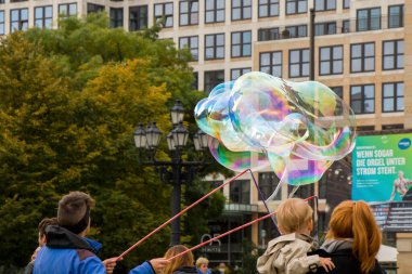 Berlin caddesinde sabun köpükleri, Almanya. Adam konser salonunun yakınında insanları ve turistleri eğlendiriyor..