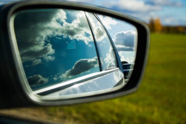 Aynaya bak. Otoyol, otoban ve yol manzarası. Otomobil, arabalar ve araçlar. Mavi gökyüzü ve güneşli bir gün. Avrupa otobanı. Doğa ve şehir birlikte..