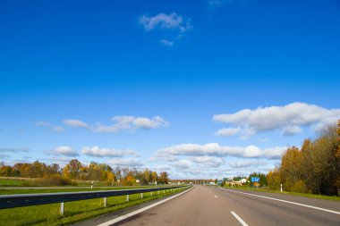Otoyol, otoban ve yol manzarası. Otomobil, arabalar ve araçlar. Mavi gökyüzü ve güneşli bir gün. Avrupa otobanı. Doğa ve şehir birlikte..