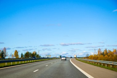 Otoyol, otoban ve yol manzarası. Otomobil, arabalar ve araçlar. Mavi gökyüzü ve güneşli bir gün. Avrupa otobanı. Doğa ve şehir birlikte..