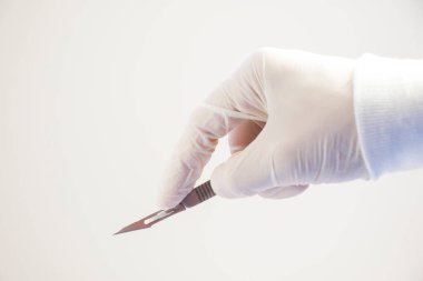 Beyaz arka planda ameliyat bıçağı duruyor, stüdyo çekimi. İşlem ekipmanı.