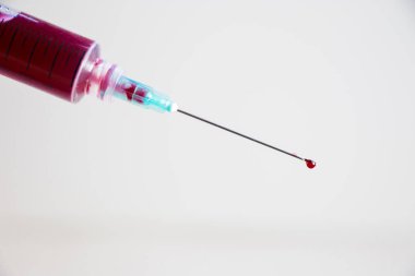 Beyaz arka planda kan olan iğne iğnesi. Laboratuvar test örneği.