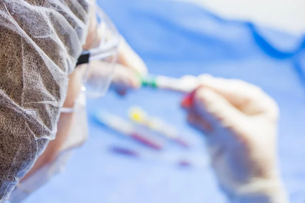 Doctors face and hands, tube and glove, laboratory situation. Blur photo for copy space.