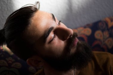 Karanlık arka planda, güneş ışığında ve odada insan portresi.