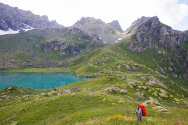 Gürcistan 'ın Svaneti şehrinde yürüyüş ve yürüyüş yapan gezgin ve gezgin, genç ve yetişkin bir kadın..