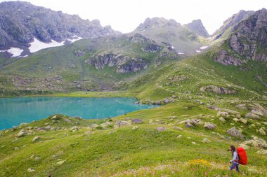 Gürcistan 'ın Svaneti şehrinde yürüyüş ve yürüyüş yapan gezgin ve gezgin, genç ve yetişkin bir kadın..