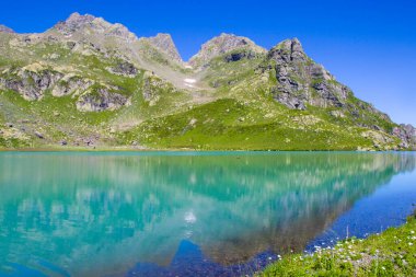 Gündüz Alp Dağı Gölü, güneş ışığı ve Svaneti, Georgia 'daki Altın Su Gölü' nün renkli manzarası..