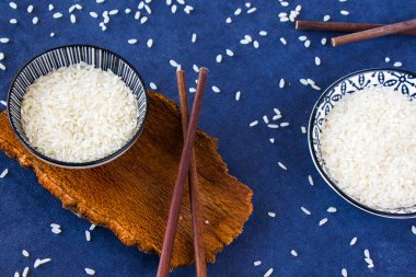 Asya sofra takımı, çiğ pirinç, kase ve yemek çubukları, ahşap malzeme, seramik kase. Pirinç tohumları.