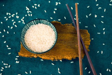 Asya sofra takımı, çiğ pirinç, kase ve yemek çubukları, ahşap malzeme, seramik kase. Pirinç tohumları.