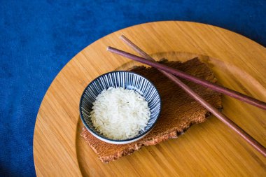 Asya sofra takımı, çiğ pirinç, kase ve yemek çubukları, ahşap malzeme, seramik kase. Pirinç tohumları.