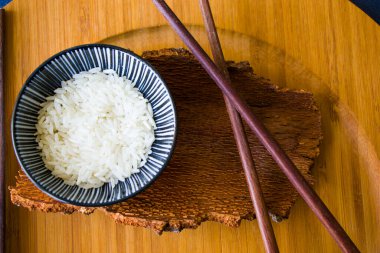 Asya sofra takımı, çiğ pirinç, kase ve yemek çubukları, ahşap malzeme, seramik kase. Pirinç tohumları.