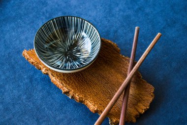 Boş Asyalı bulaşık takımı, kase, ezme ve yemek çubukları mavi arka planda, restoran sofra takımı