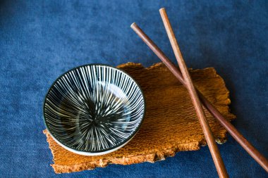 Boş Asyalı bulaşık takımı, kase, ezme ve yemek çubukları mavi arka planda, restoran sofra takımı