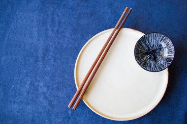 Boş Asyalı bulaşık takımı, kase, ezme ve yemek çubukları mavi arka planda, restoran sofra takımı