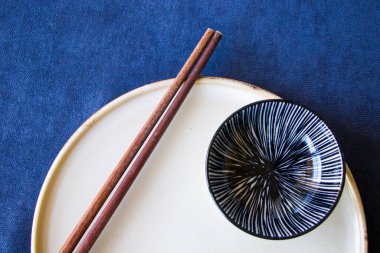 Boş Asyalı bulaşık takımı, kase, ezme ve yemek çubukları mavi arka planda, restoran sofra takımı