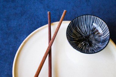 Boş Asyalı bulaşık takımı, kase, ezme ve yemek çubukları mavi arka planda, restoran sofra takımı