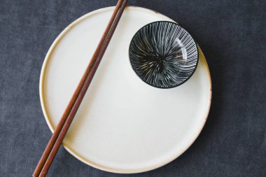 Boş Asyalı bulaşık takımı, kase, ezme ve yemek çubukları mavi arka planda, restoran sofra takımı