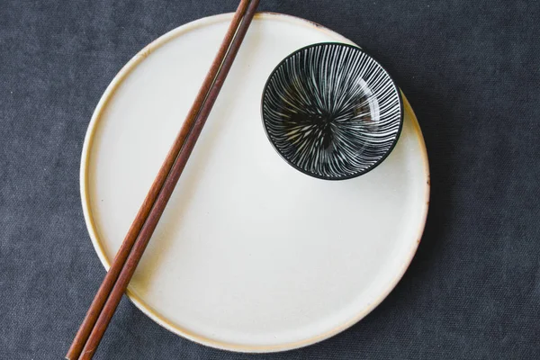 Boş Asyalı bulaşık takımı, kase, ezme ve yemek çubukları mavi arka planda, restoran sofra takımı