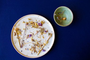 Sonbahar kurutulmuş bitkiler ve mavi arka planda bir çiçek, stüdyo çekimi.