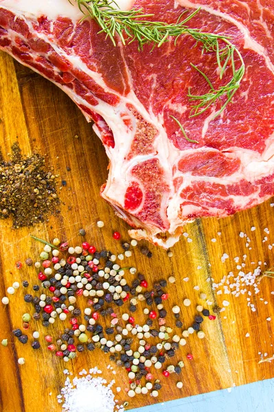 Masada çiğ et, baharat ve biberiye, biftek malzemeleri. Biber ve kaba tuz.