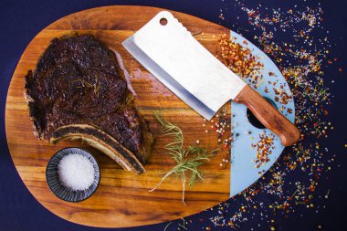 Tahtada biftek, tuz, biber ve biberiye..