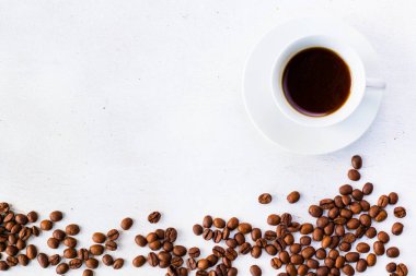 Beyaz arka planda kahve fincanında espresso ve kahve çekirdeği.